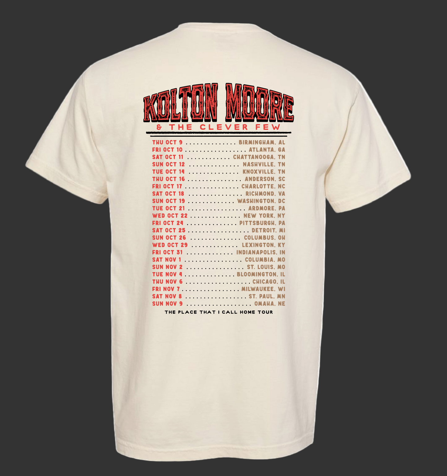 Beige t-shirt with red and black text on the back, featuring a tour schedule.